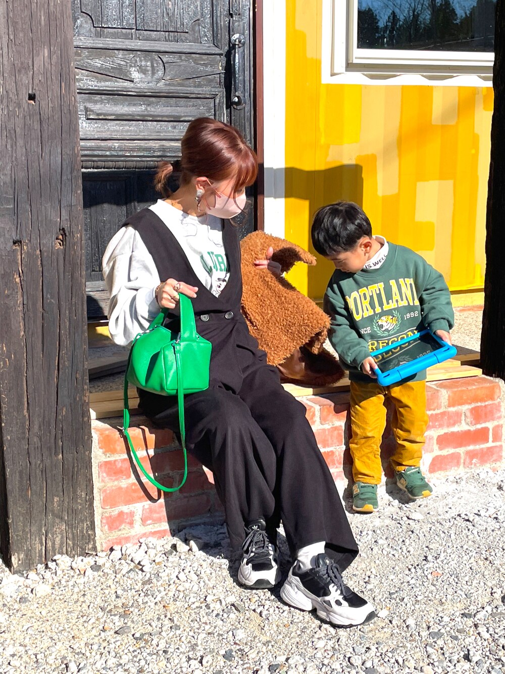 グレー系のスウェット、ブラック系のオールインワン・サロペット、グリーン系のその他アウターを着用したレディースの冬コーディネートの1枚目の写真