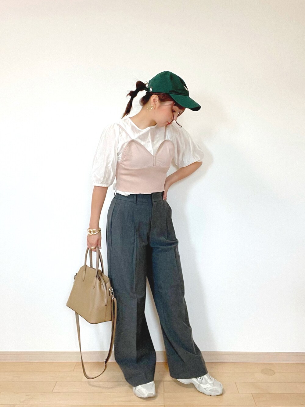 グレー系のパンツ、ブラウン系のキャミソール、ホワイト系のスニーカーを着用したレディースの秋コーディネートの1枚目の写真