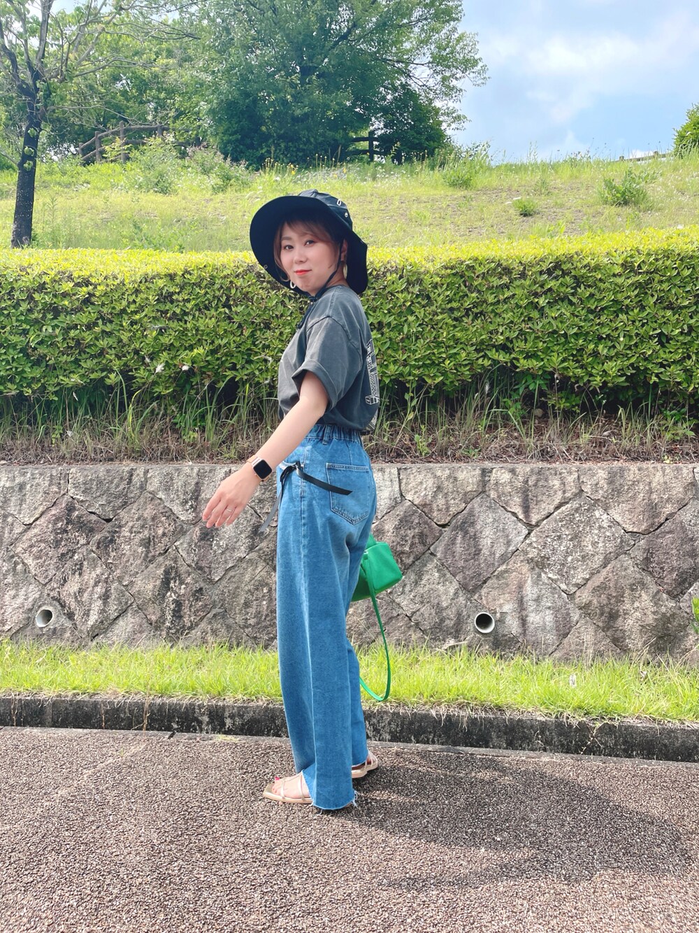 グレー系のTシャツ/カットソー、ブルー系のデニムパンツ、ゴールド系のサンダルを着用したレディースの夏コーディネートの1枚目の写真