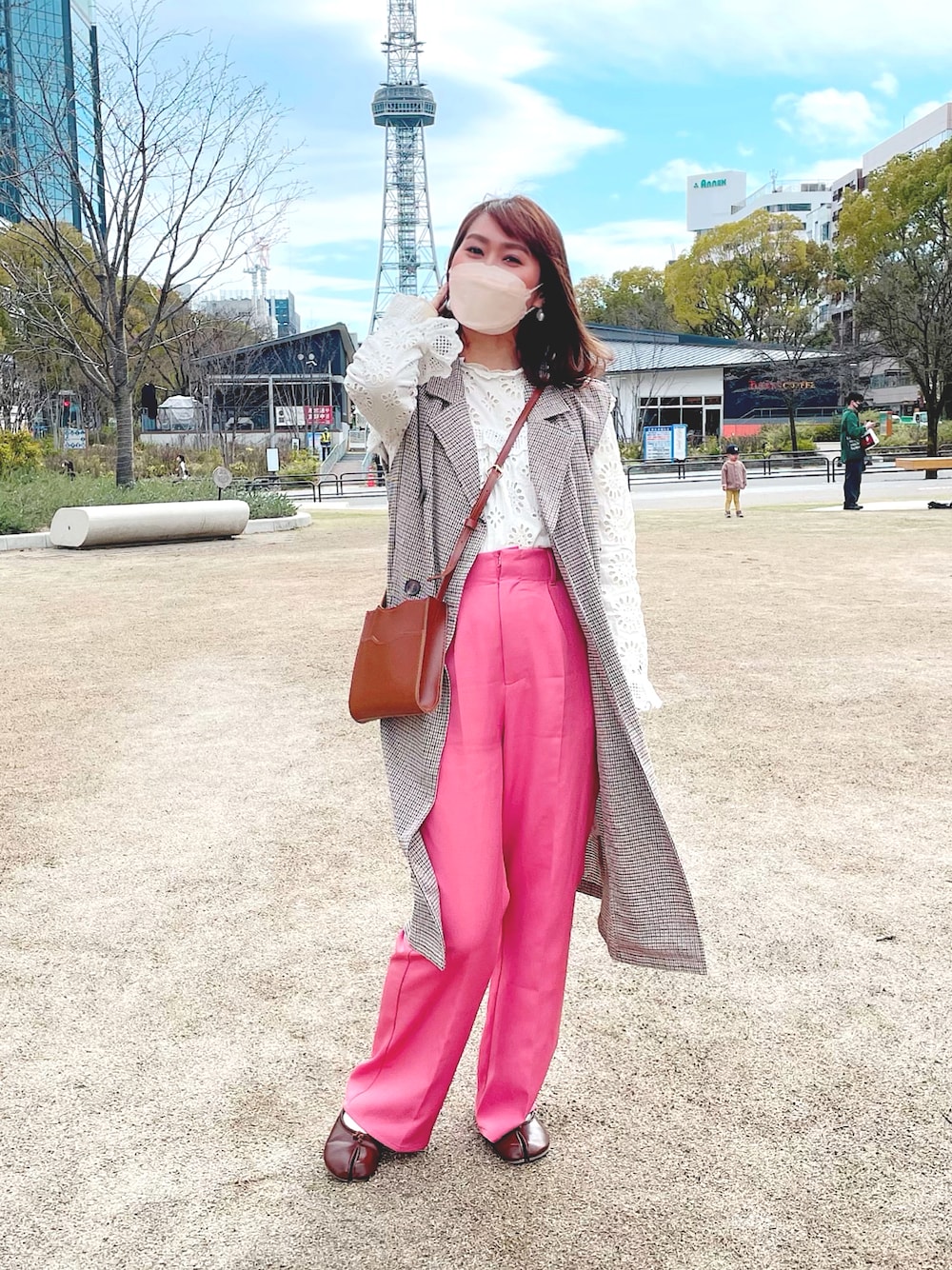 ピンク系のスラックス、ホワイト系のシャツ/ブラウス、ベージュ系のトレンチコートを着用したレディースの春コーディネートの1枚目の写真