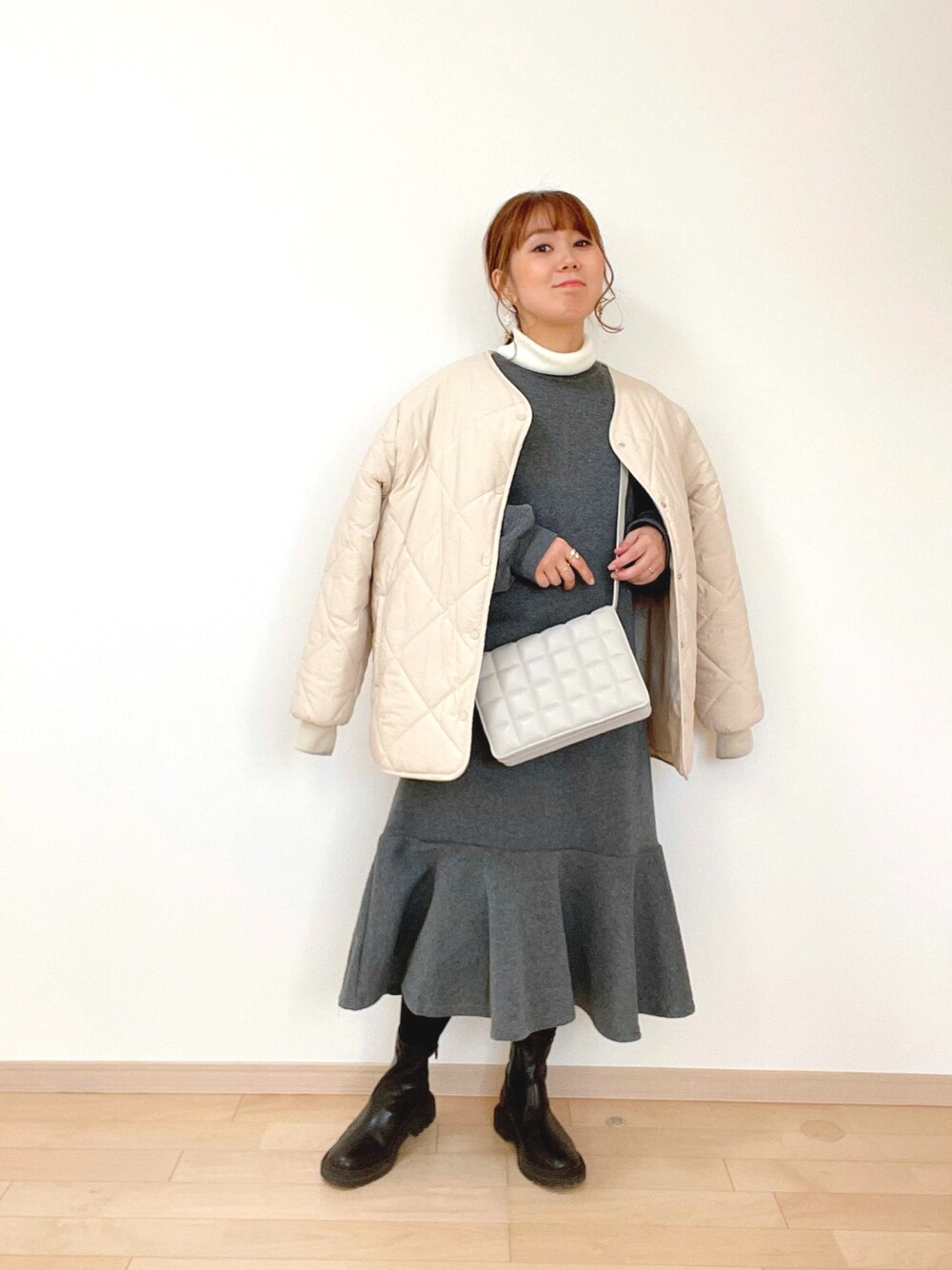 グレー系のワンピース、ホワイト系のノーカラーコート、ホワイト系のニット/セーターを着用したレディースの冬コーディネートの1枚目の写真