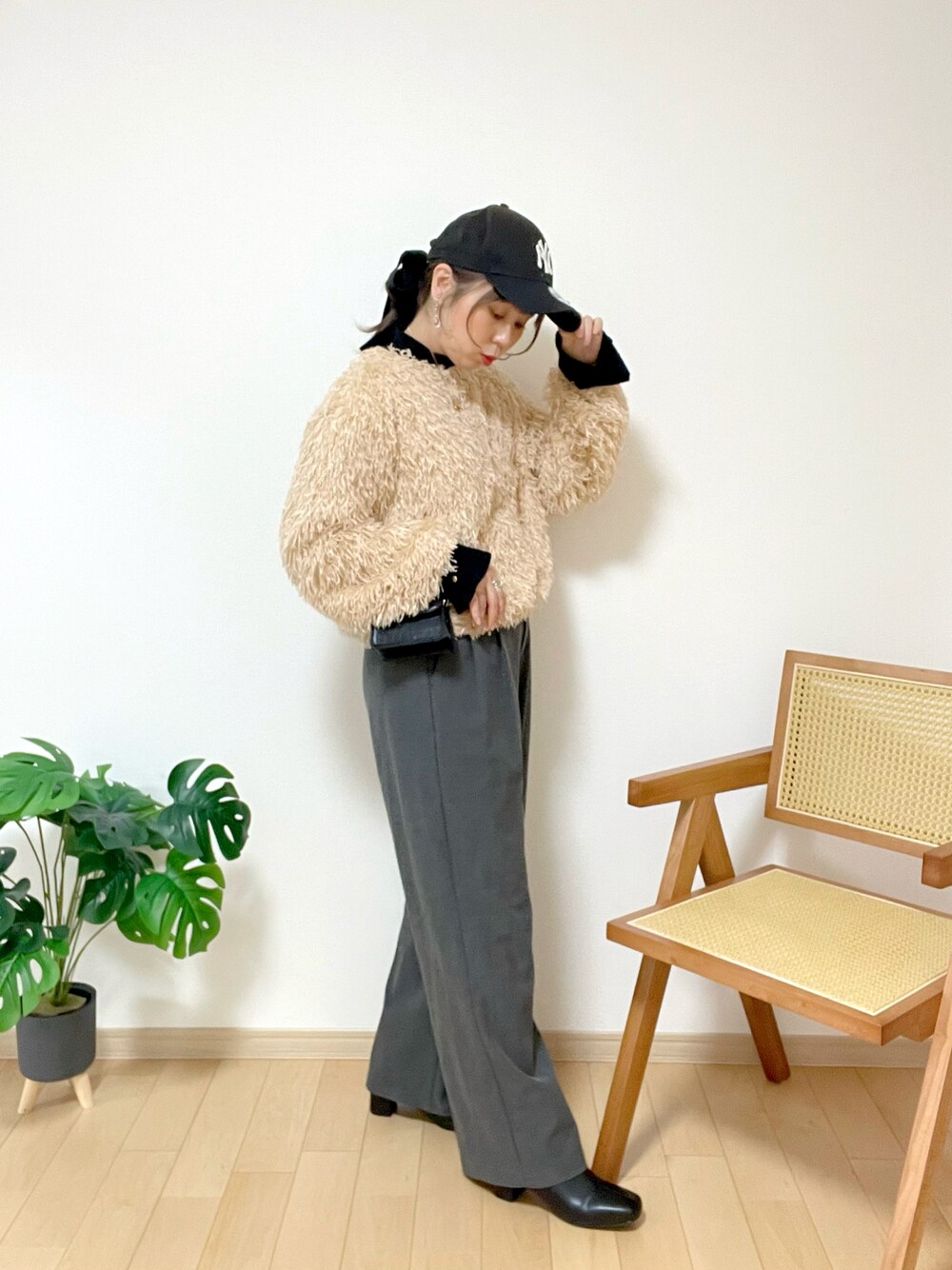 ピンク系のニット/セーター、ブラック系のニット/セーター、グレー系のパンツを着用したレディースの冬コーディネートの1枚目の写真