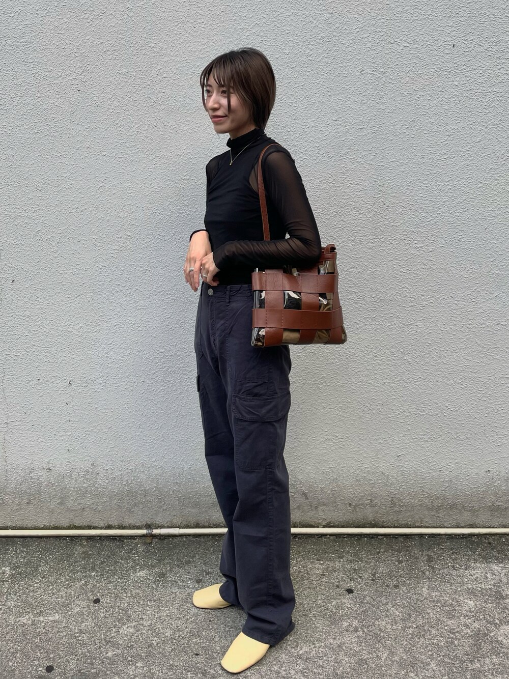 ブラック系のトップス、ブラック系のカーゴパンツ、イエロー系のシューズを着用したレディースの秋コーディネートの1枚目の写真