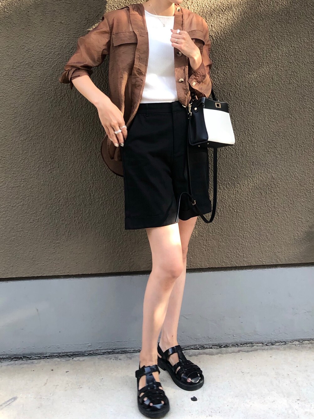 ホワイト系のタンクトップ、ホワイト系のショルダーバッグ、ブラック系のその他パンツを着用したレディースの夏コーディネートの1枚目の写真