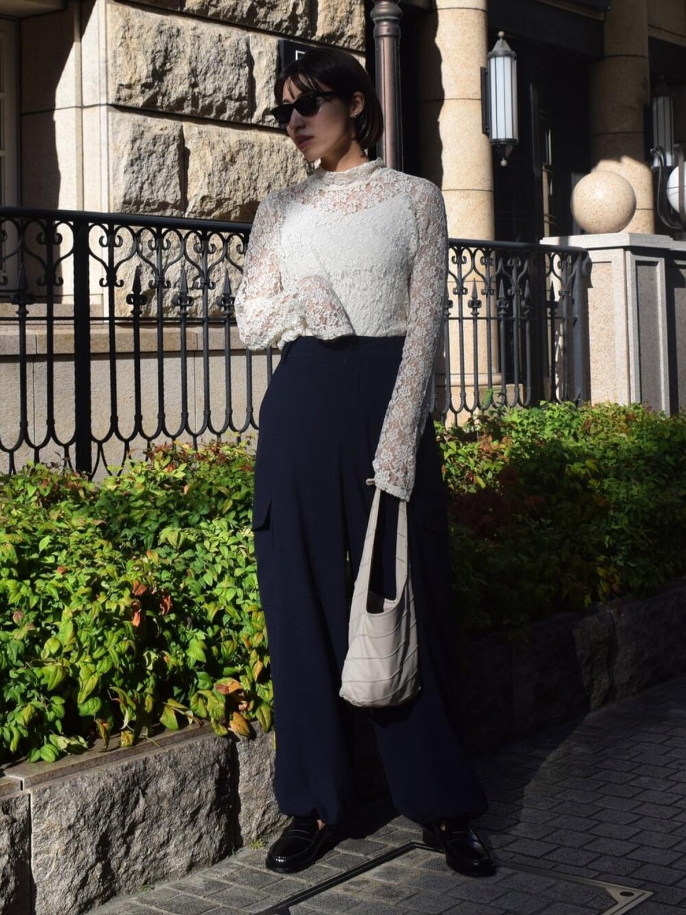 ホワイト系のTシャツ/カットソー、ブルー系のカーゴパンツ、ホワイト系のハンドバッグを着用したレディースの秋コーディネートの1枚目の写真