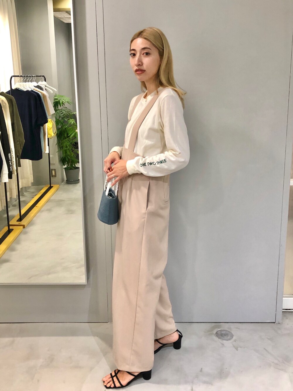 ホワイト系のTシャツ/カットソー、ブルー系のハンドバッグ、ブラック系のサンダルを着用したレディースの秋コーディネートの1枚目の写真