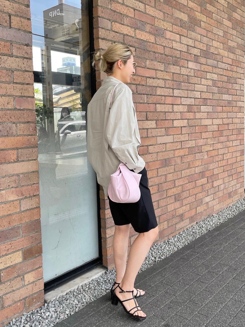 ピンク系のショルダーバッグ、ブラック系のサンダル、ホワイト系のシャツ/ブラウスを着用したレディースの春コーディネートの1枚目の写真