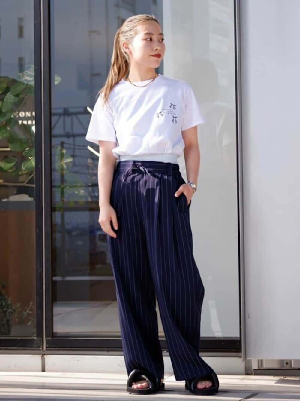 ホワイト系のTシャツ/カットソー、ブルー系のスラックスを着用したレディースの夏コーディネートの1枚目の写真