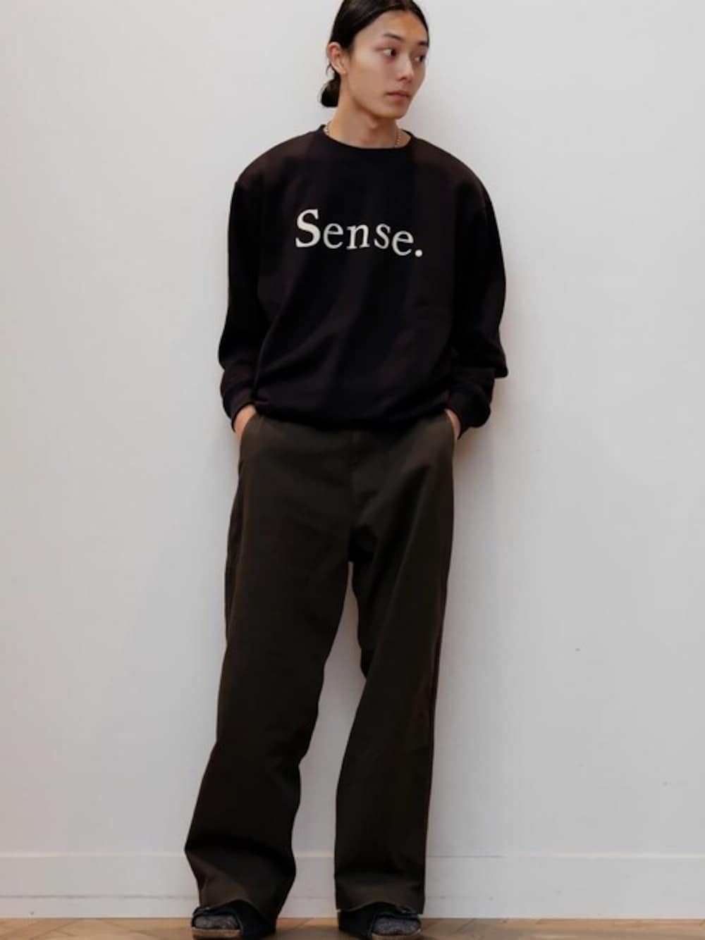 ブラック系のスウェット、グレー系のチノパンツを着用したメンズの秋コーディネートの1枚目の写真