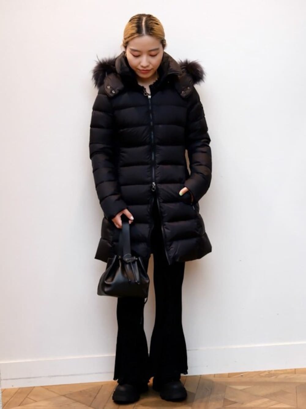 ブラック系のダウンジャケット/コート、ブラック系のベスト、ブラック系のブーツを着用したレディースの秋コーディネートの1枚目の写真