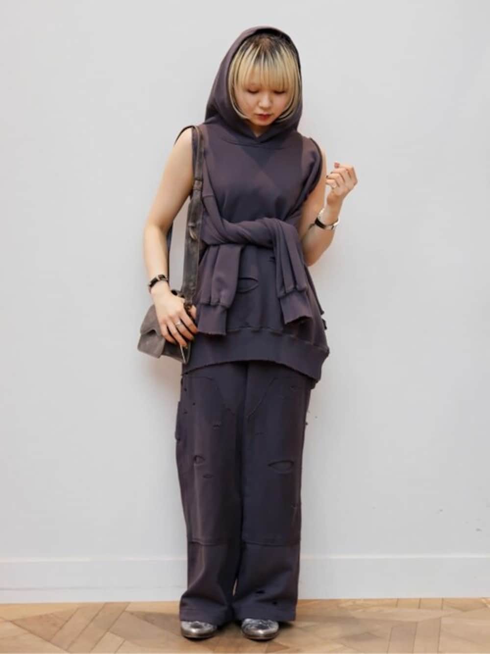 グレー系のパーカー、グレー系のスウェットパンツ、ブラウン系のショルダーバッグを着用したレディースの冬コーディネートの1枚目の写真