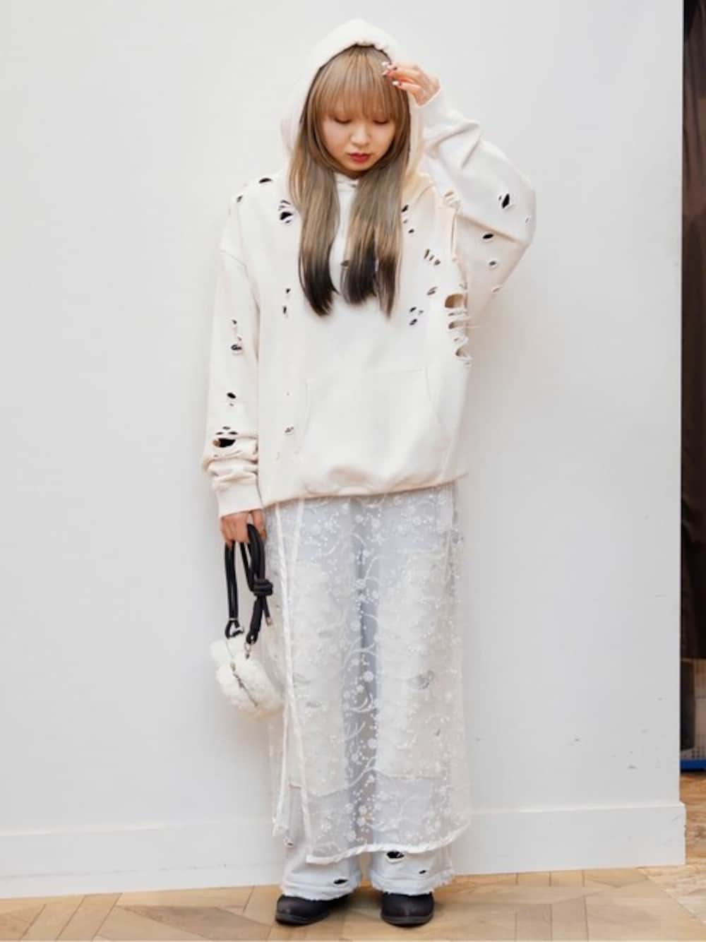 グレー系のスウェットパンツ、ホワイト系のスカート、ベージュ系のパーカーを着用したレディースの冬コーディネートの1枚目の写真