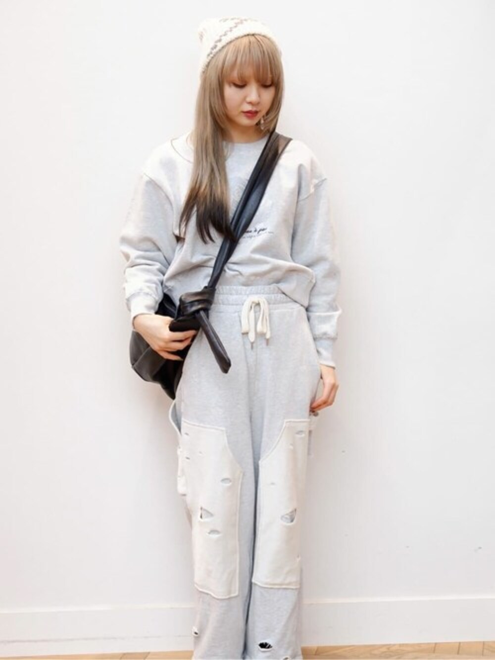 グレー系のスウェットパンツ、ブラック系のショルダーバッグ、グレー系のスウェットを着用したレディースの冬コーディネートの1枚目の写真