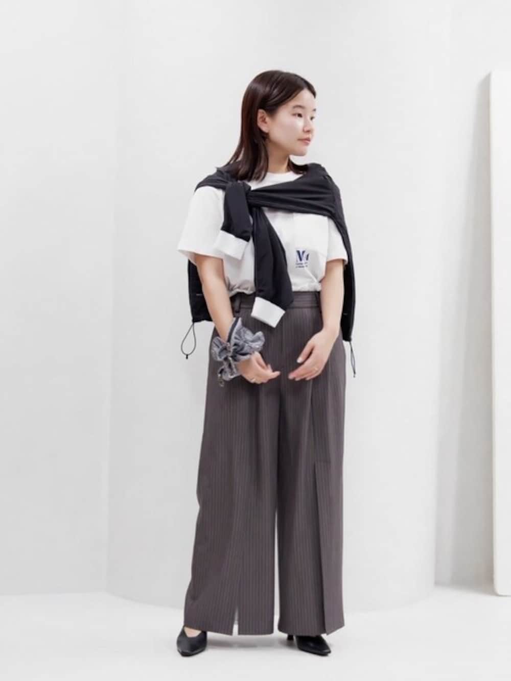 ホワイト系のTシャツ/カットソー、グレー系のスラックス、ブラック系のTシャツ/カットソーを着用したレディースの春コーディネートの1枚目の写真