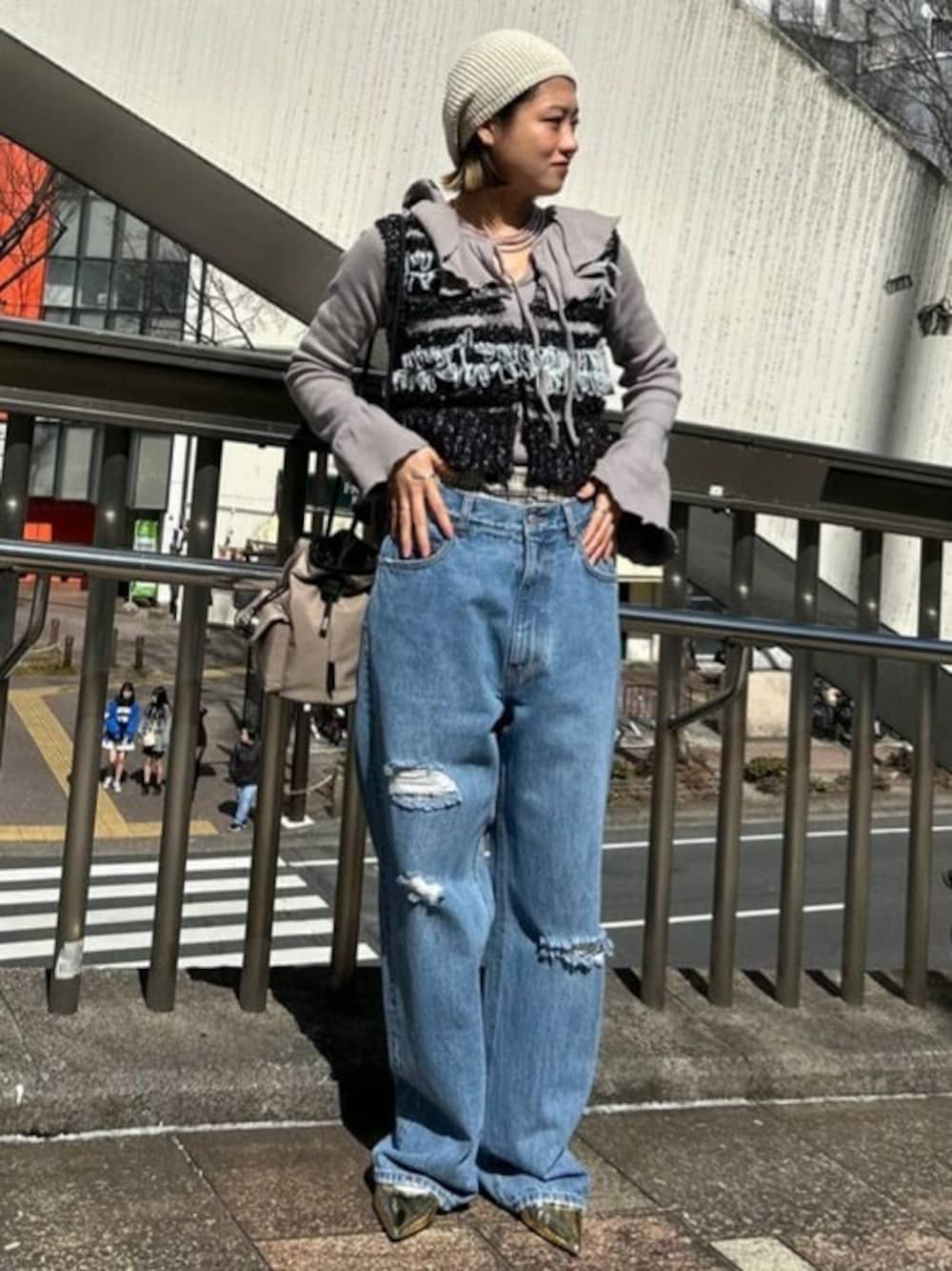 ブラック系のベスト、グレー系のTシャツ/カットソー、ブルー系のデニムパンツを着用したレディースの春コーディネートの1枚目の写真