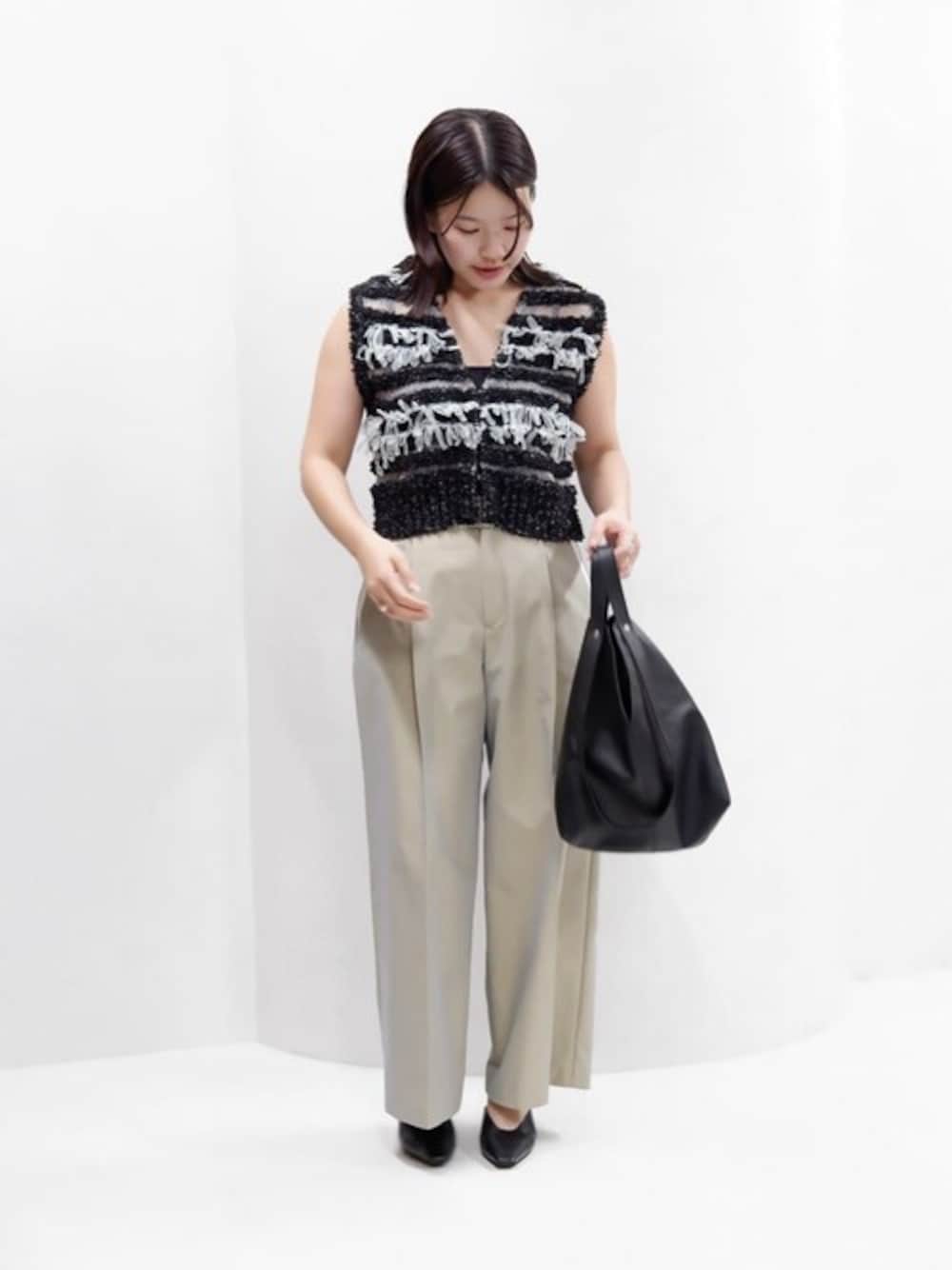 ブラック系のベスト、ブルー系のその他パンツ、ブラック系のトートバッグを着用したレディースの春コーディネートの1枚目の写真