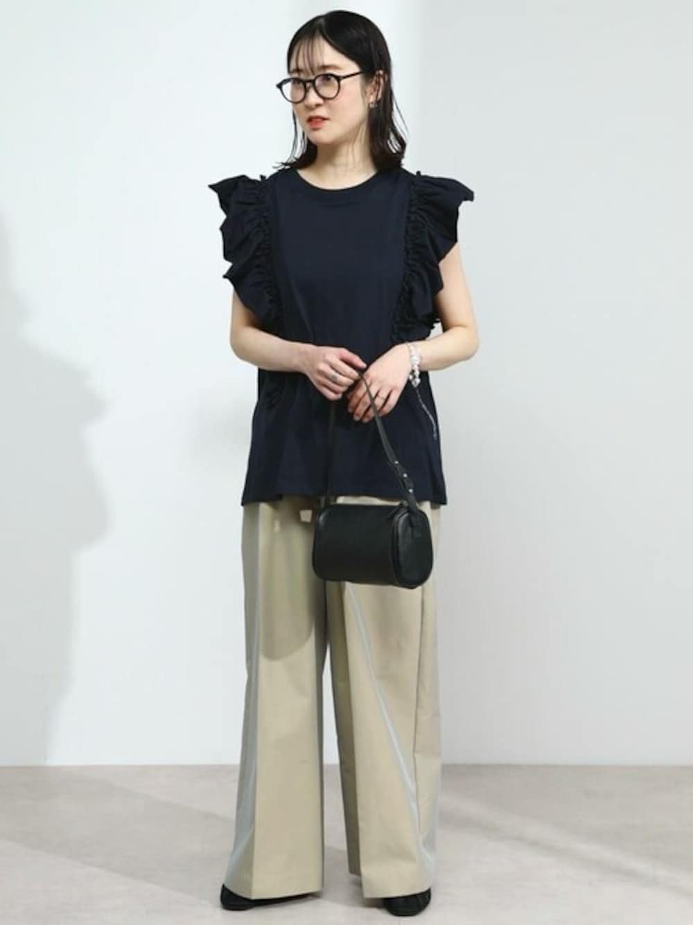 ブルー系のTシャツ/カットソー、ブラック系のハンドバッグを着用したレディースの夏コーディネートの1枚目の写真