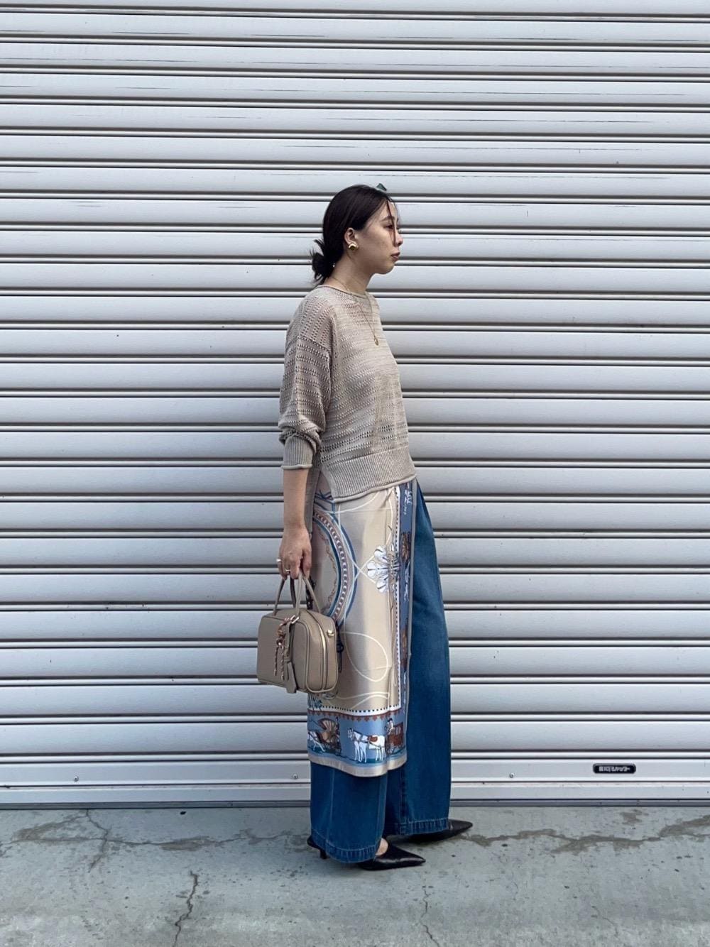 ブルー系のデニムパンツ、ベージュ系のニット/セーター、ホワイト系のニット/セーターを着用したレディースの秋コーディネートの1枚目の写真