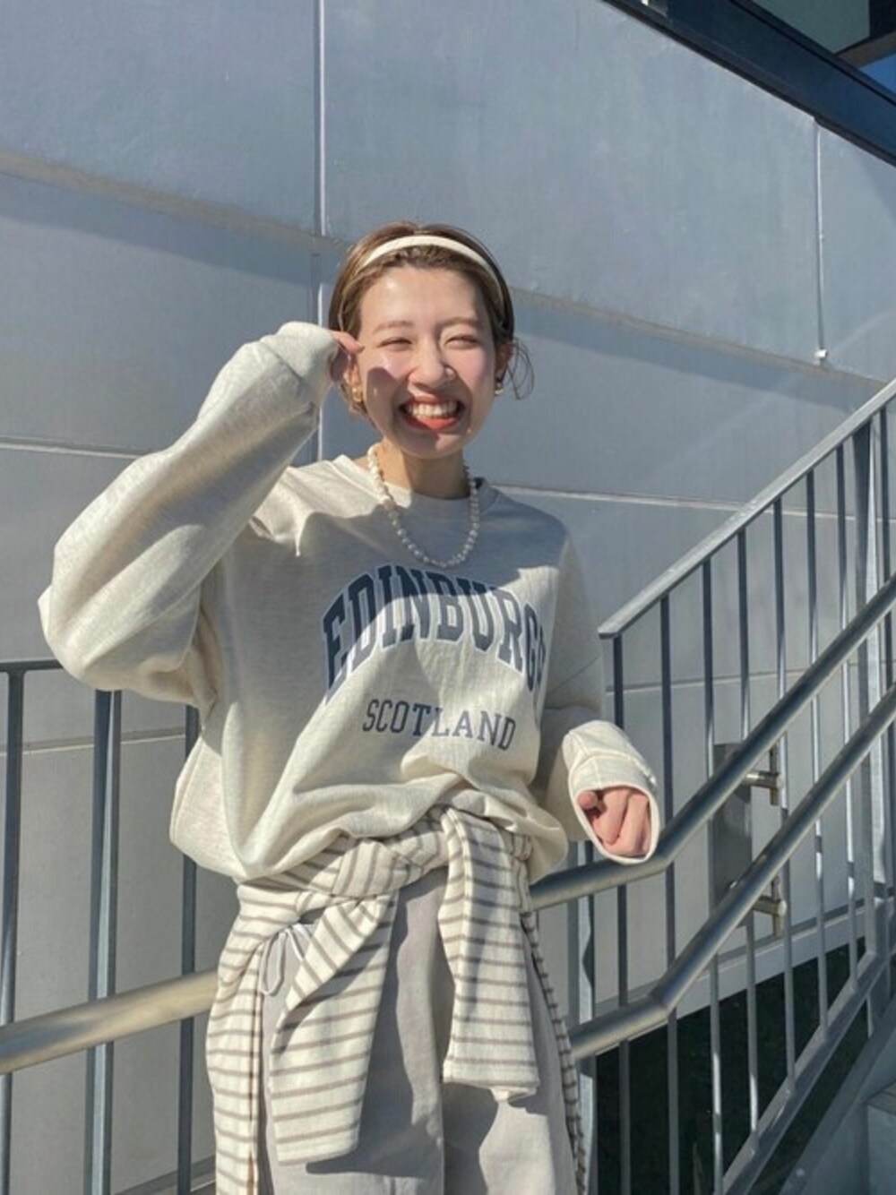 ホワイト系のスウェット、ベージュ系のTシャツ/カットソーを着用したレディースの冬コーディネートの1枚目の写真