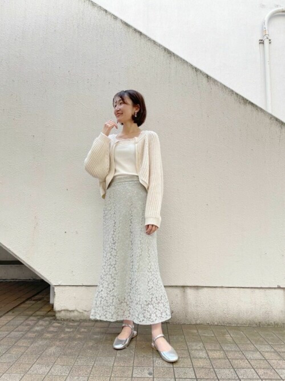 グリーン系のスカート、ホワイト系のカーディガン/ボレロを着用したレディースの春コーディネートの1枚目の写真
