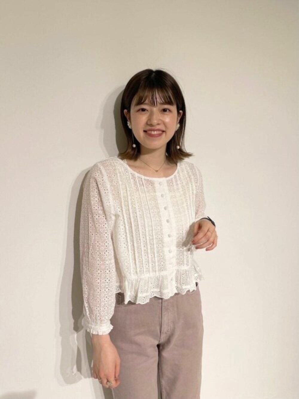 ホワイト系のシャツ/ブラウス、ゴールド系のイヤリングを着用したレディースの春コーディネートの1枚目の写真