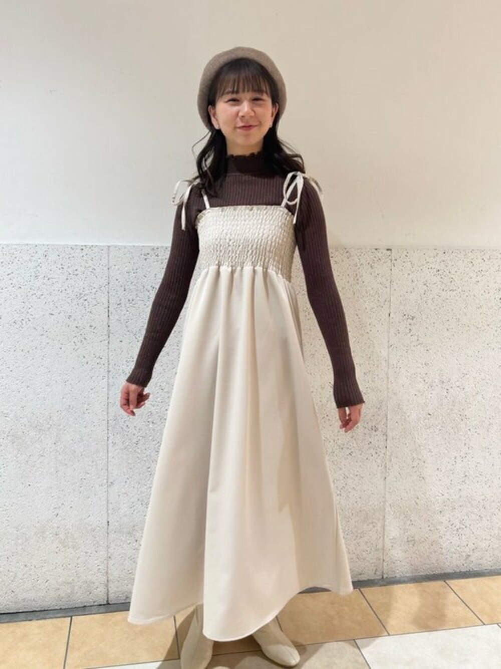 ブラウン系のニット/セーター、ホワイト系のワンピース、ホワイト系のピアス(片耳用)を着用したレディースの冬コーディネートの1枚目の写真