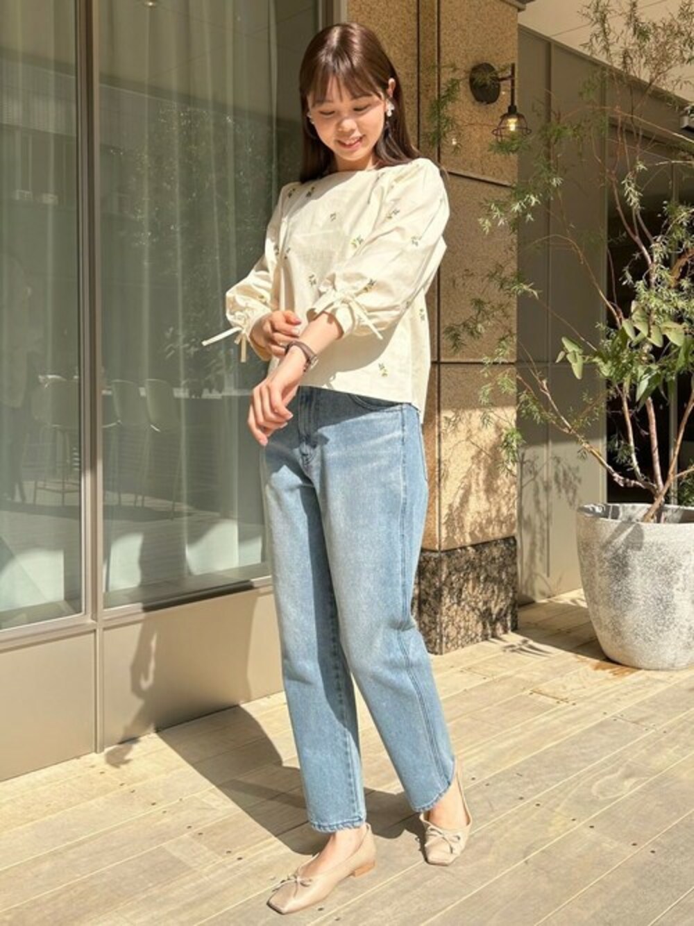 ホワイト系のシャツ/ブラウス、ブルー系のデニムパンツを着用したレディースの春コーディネートの1枚目の写真