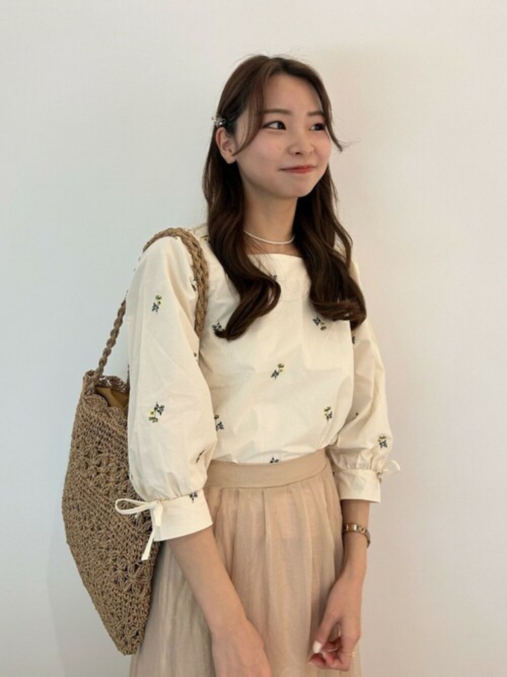 ホワイト系のシャツ/ブラウス、ブラウン系のかごバッグ、ベージュ系のバレッタ/ヘアクリップを着用したレディースの春コーディネートの1枚目の写真