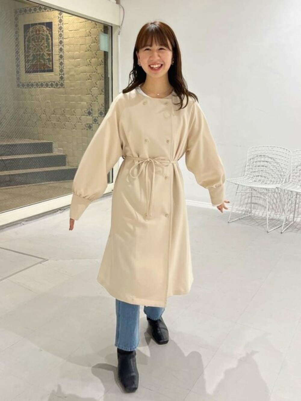 ホワイト系のトレンチコートを着用したレディースの春コーディネートの1枚目の写真