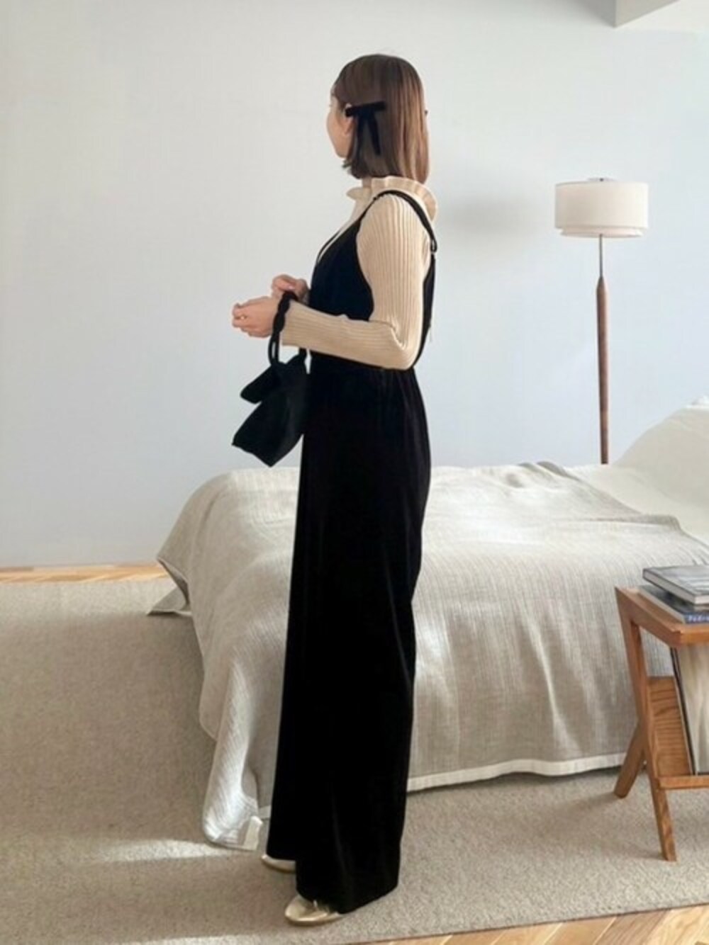 ブラック系のつなぎ/オールインワン、ベージュ系のニット/セーター、ブラック系のショルダーバッグを着用したレディースの冬コーディネートの1枚目の写真