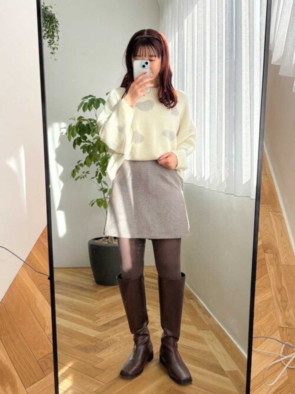 ホワイト系のニット/セーター、ブラウン系のスカートを着用したレディースの冬コーディネートの1枚目の写真