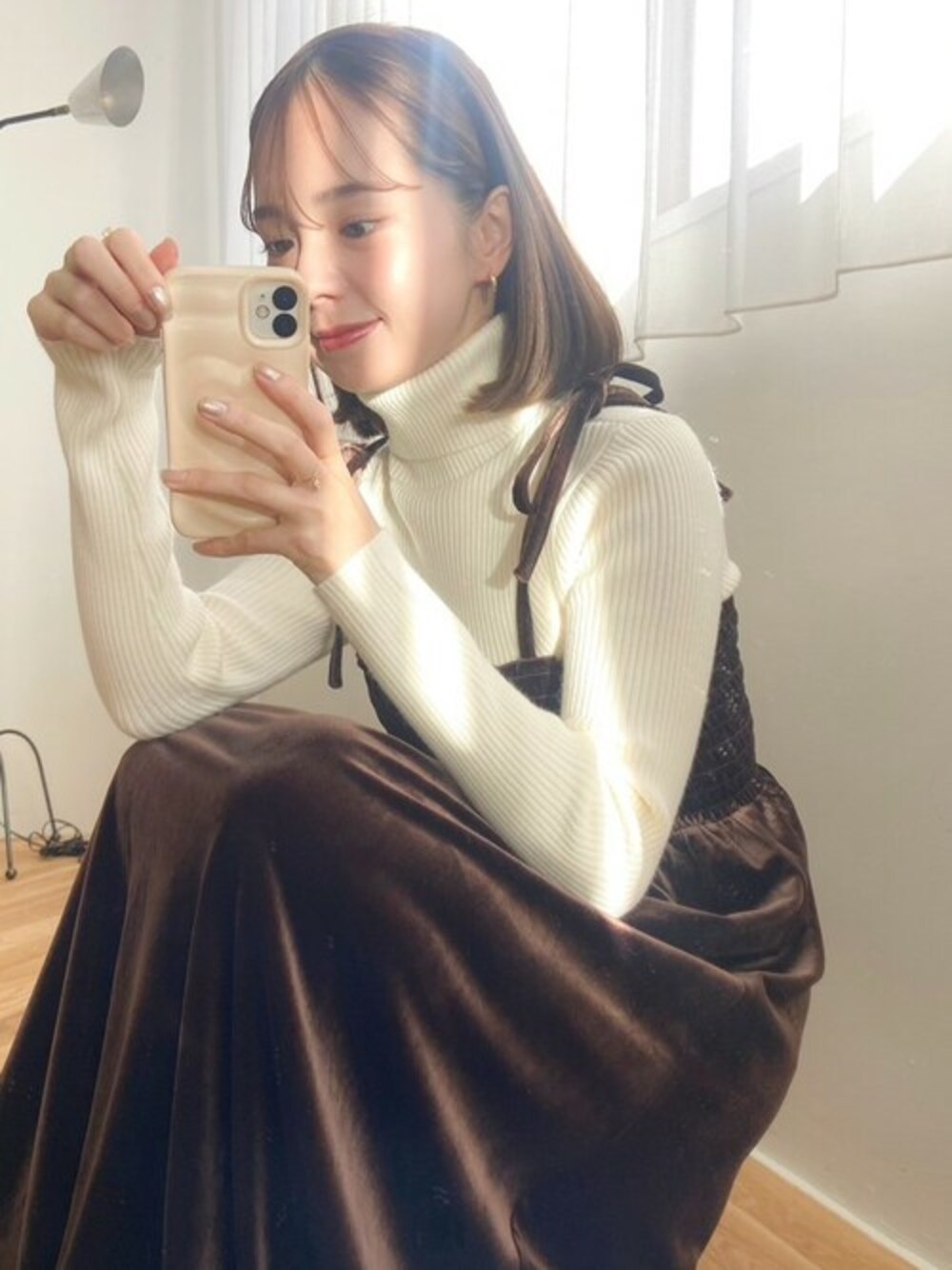 ブラウン系のワンピース、ホワイト系のニット/セーターを着用したレディースの冬コーディネートの1枚目の写真