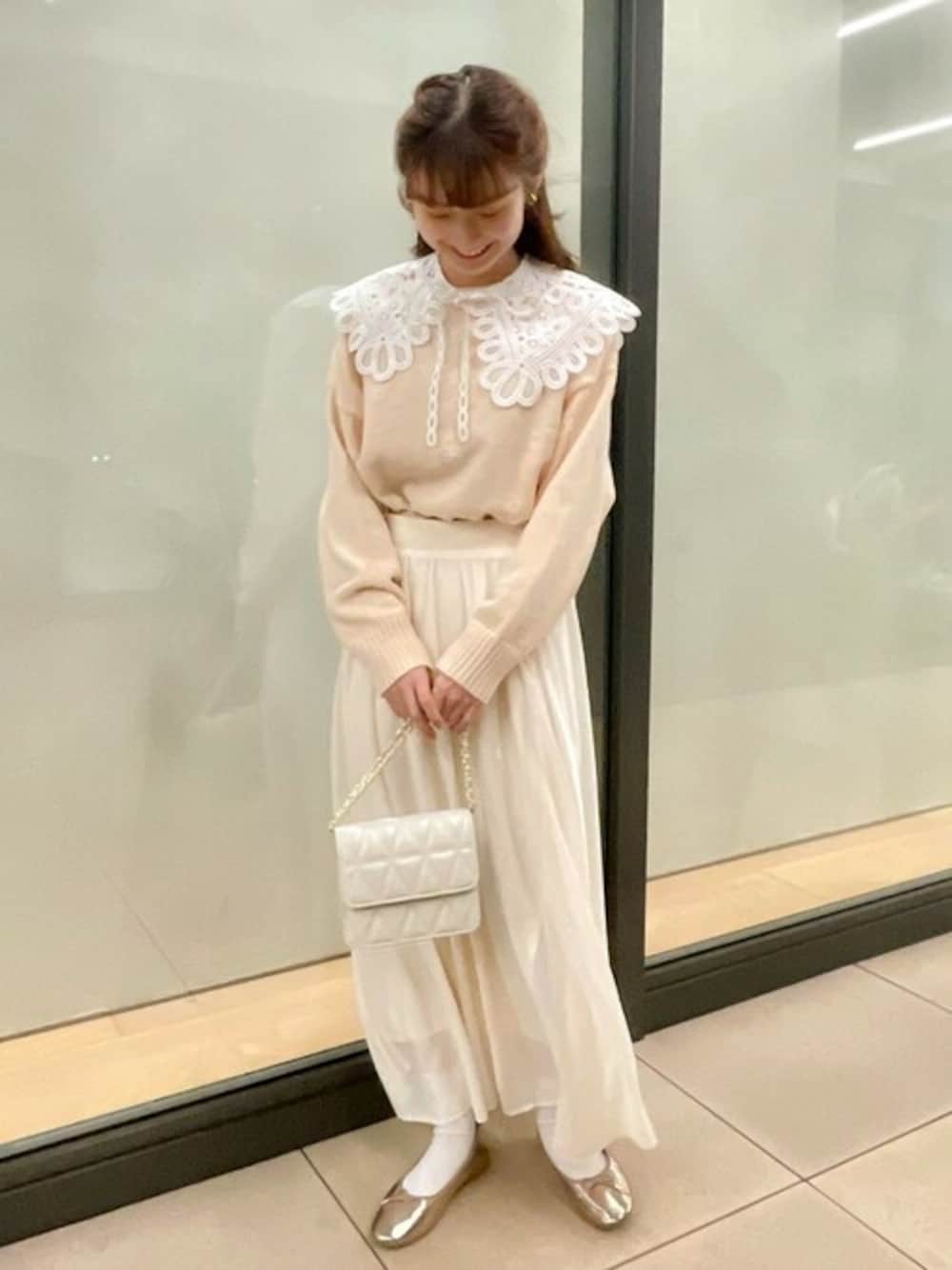 ピンク系のニット/セーター、ホワイト系のスカート、ホワイト系のショルダーバッグを着用したレディースの冬コーディネートの1枚目の写真