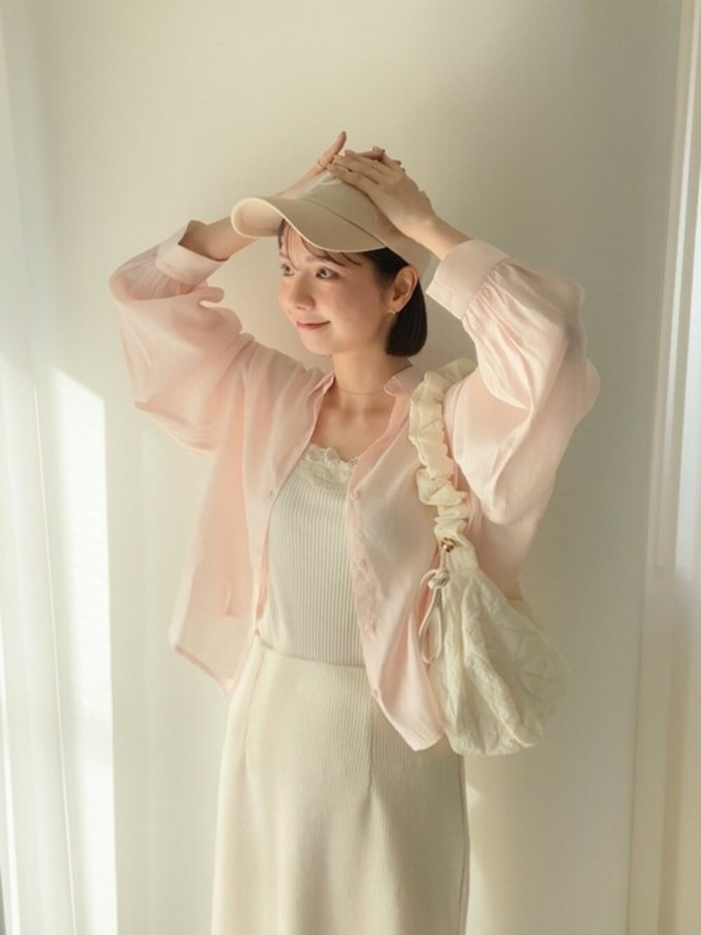 ピンク系のシャツ/ブラウス、ホワイト系のスカート、ホワイト系のショルダーバッグを着用したレディースの春コーディネートの1枚目の写真