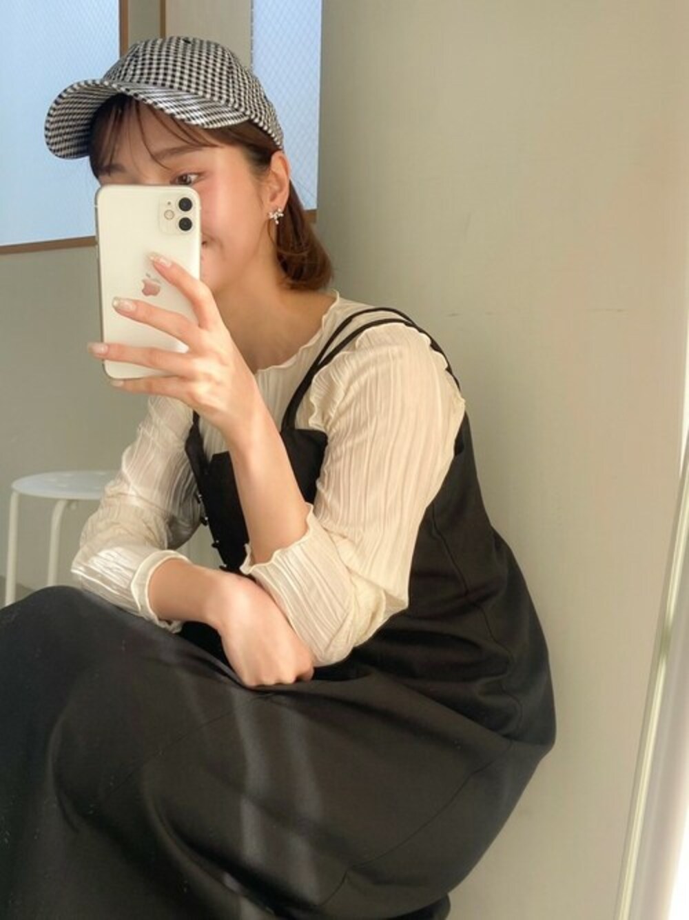 ブラック系のワンピース、ホワイト系のTシャツ/カットソー、ブラック系のキャップを着用したレディースの春コーディネートの1枚目の写真