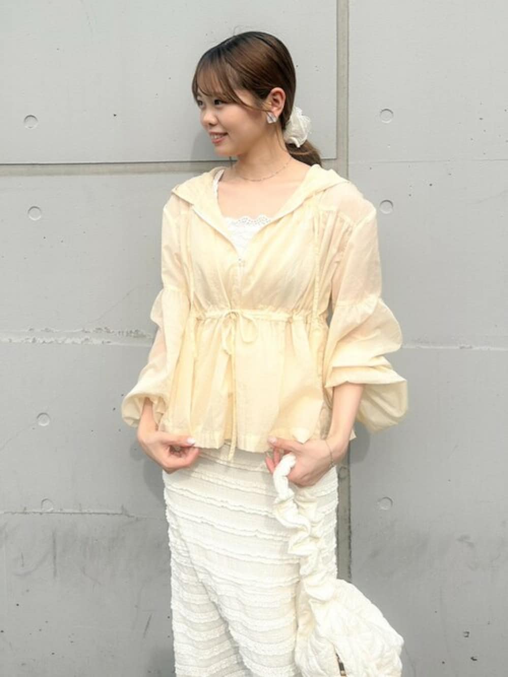 ホワイト系のスカート、ベージュ系のナイロンジャケット、ホワイト系のショルダーバッグを着用したレディースの春コーディネートの1枚目の写真