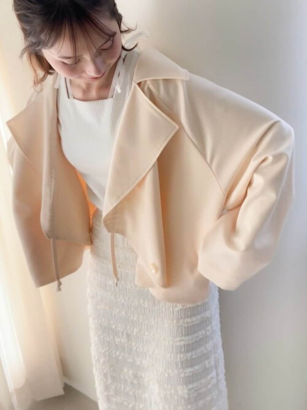 ホワイト系のスカート、ホワイト系のタンクトップ、ホワイト系のトレンチコートを着用したレディースの春コーディネートの1枚目の写真