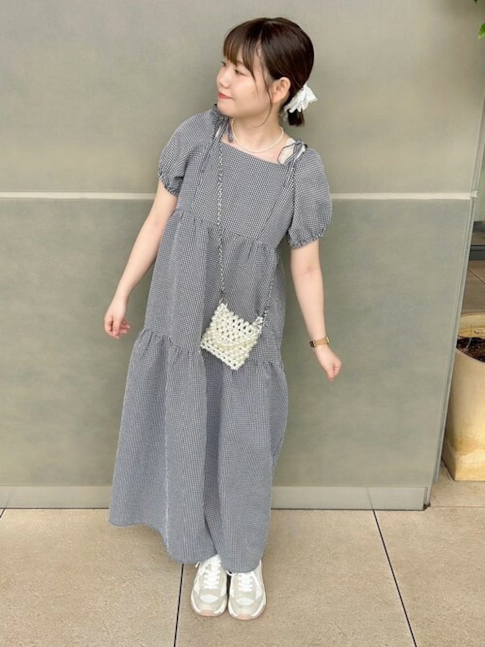 ブラック系のワンピース、ホワイト系のシュシュを着用したレディースの夏コーディネートの1枚目の写真