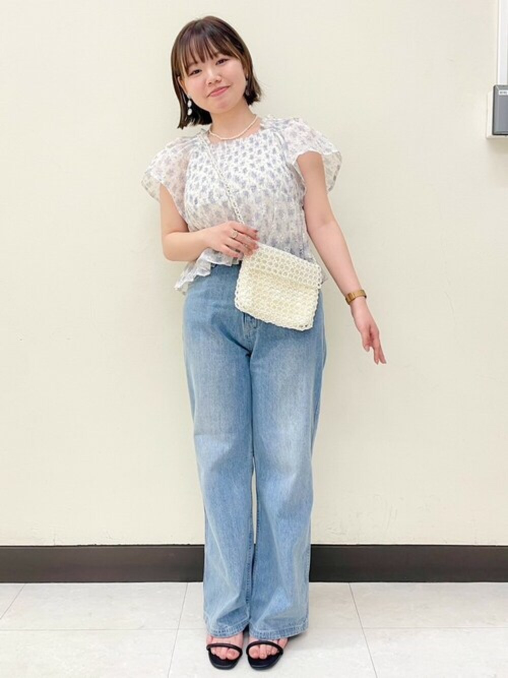 パープル系のシャツ/ブラウス、ブルー系のデニムパンツ、ホワイト系のショルダーバッグを着用したレディースの夏コーディネートの1枚目の写真