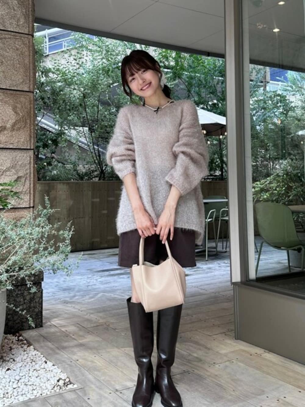 ブラウン系のスカート、ベージュ系のニット/セーター、ベージュ系のショルダーバッグを着用したレディースの秋コーディネートの1枚目の写真