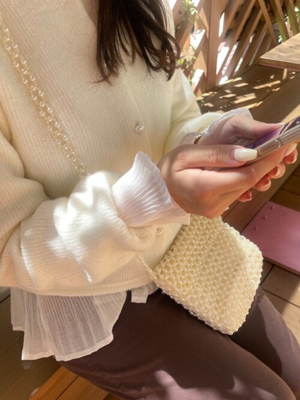 ホワイト系のニット/セーター、ブラウン系のその他パンツ、ホワイト系のシャツ/ブラウスを着用したレディースの秋コーディネートの1枚目の写真