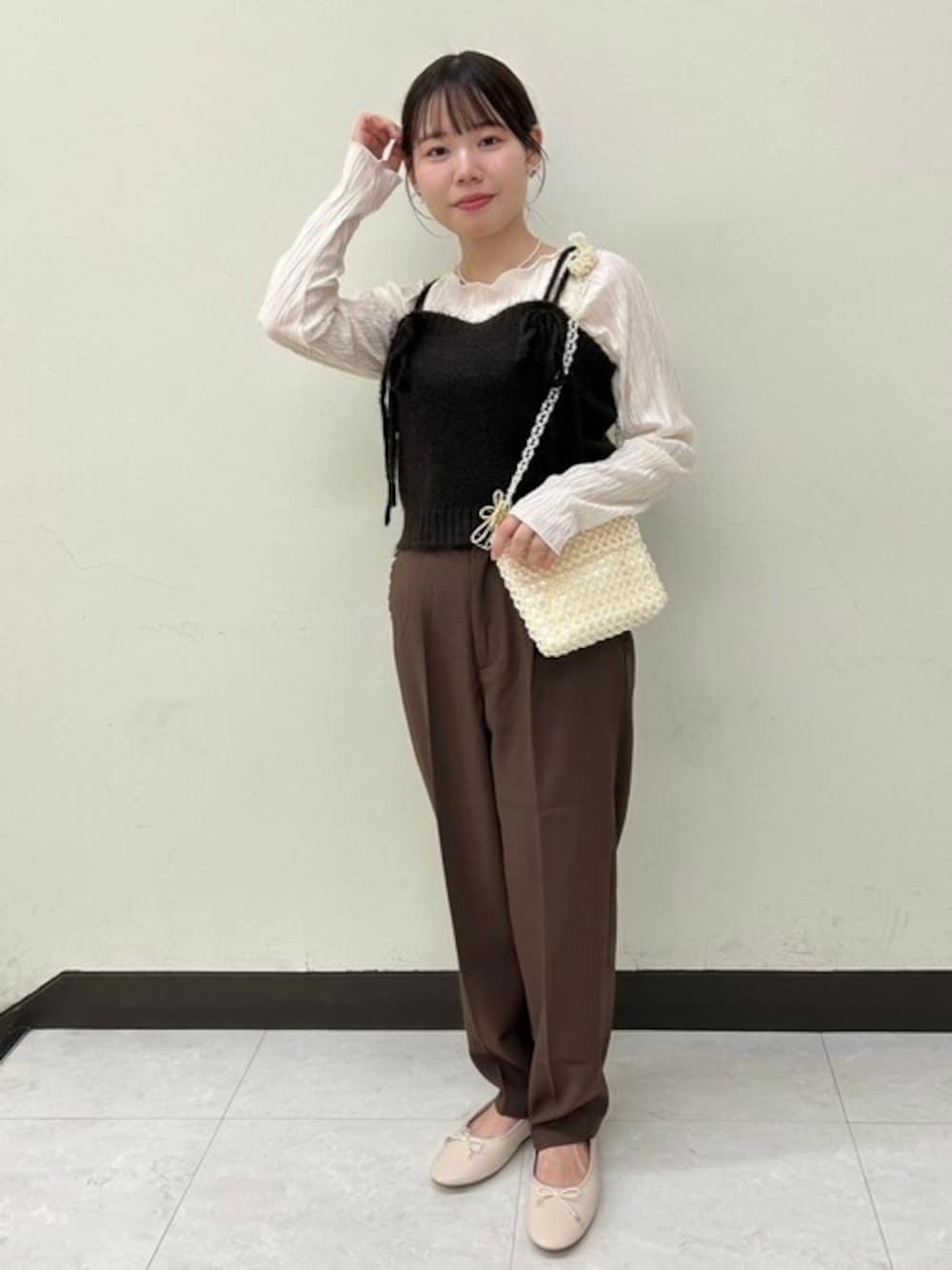 ブラウン系のニット/セーター、ブラウン系のその他パンツ、ホワイト系のTシャツ/カットソーを着用したレディースの秋コーディネートの1枚目の写真