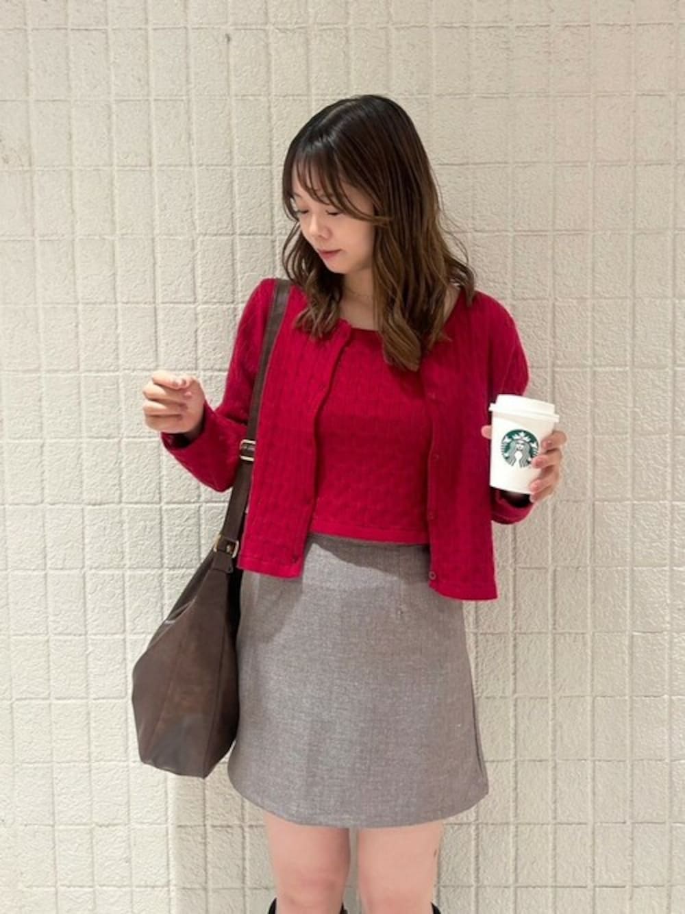 レッド系のニット/セーター、ブラウン系のスカートを着用したレディースの秋コーディネートの1枚目の写真