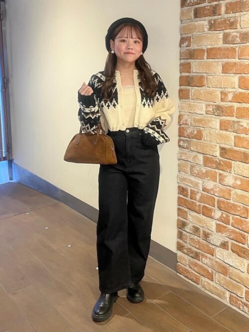 ホワイト系のニット/セーター、ブラック系のデニムパンツ、ブラウン系のハンドバッグを着用したレディースの冬コーディネートの1枚目の写真