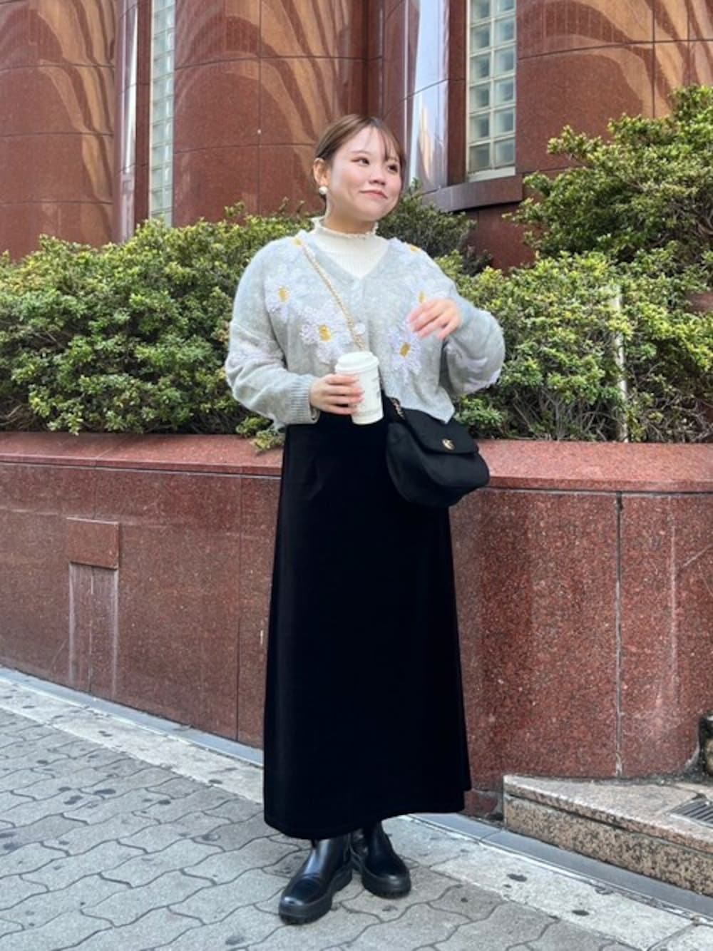 ブラック系のスカート、グレー系のニット/セーター、ホワイト系のニット/セーターを着用したレディースの冬コーディネートの1枚目の写真