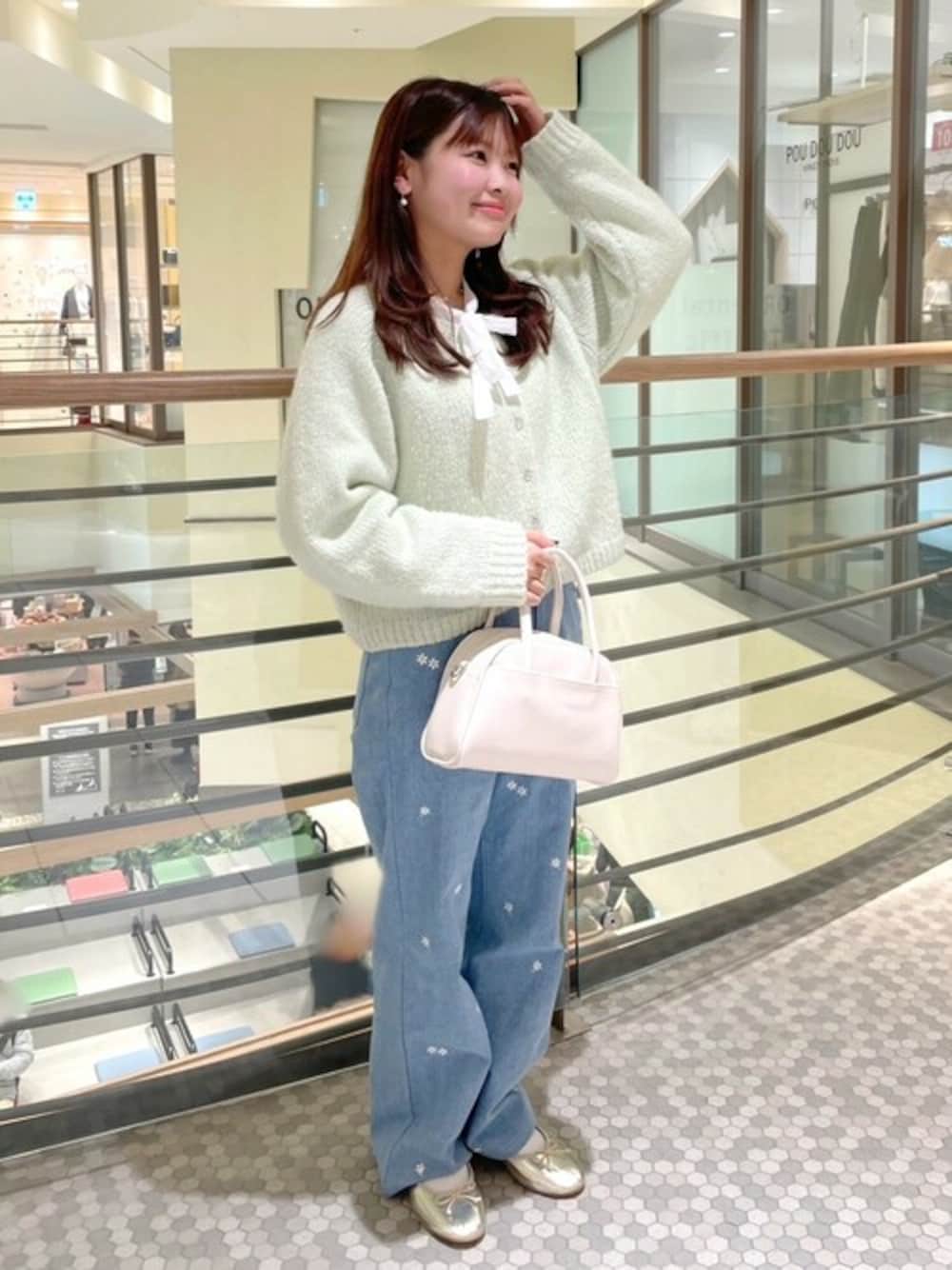 ブルー系のデニムパンツ、ホワイト系のシャツ/ブラウス、ホワイト系のハンドバッグを着用したレディースの春コーディネートの1枚目の写真