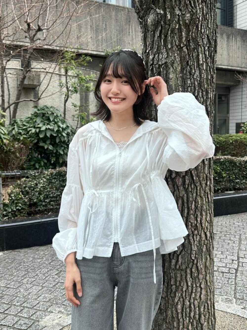 ホワイト系のナイロンジャケットを着用したレディースの春コーディネートの1枚目の写真