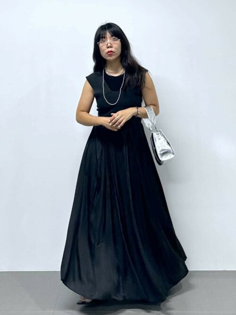 ブラック系のワンピース、ブラック系のニット/セーター、ブラック系のスカートを着用したレディースの秋コーディネートの1枚目の写真