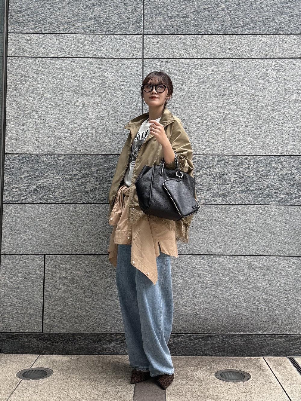 ブルー系のデニムパンツ、ベージュ系のシャツ/ブラウス、ブラック系のトートバッグを着用したレディースの秋コーディネートの1枚目の写真
