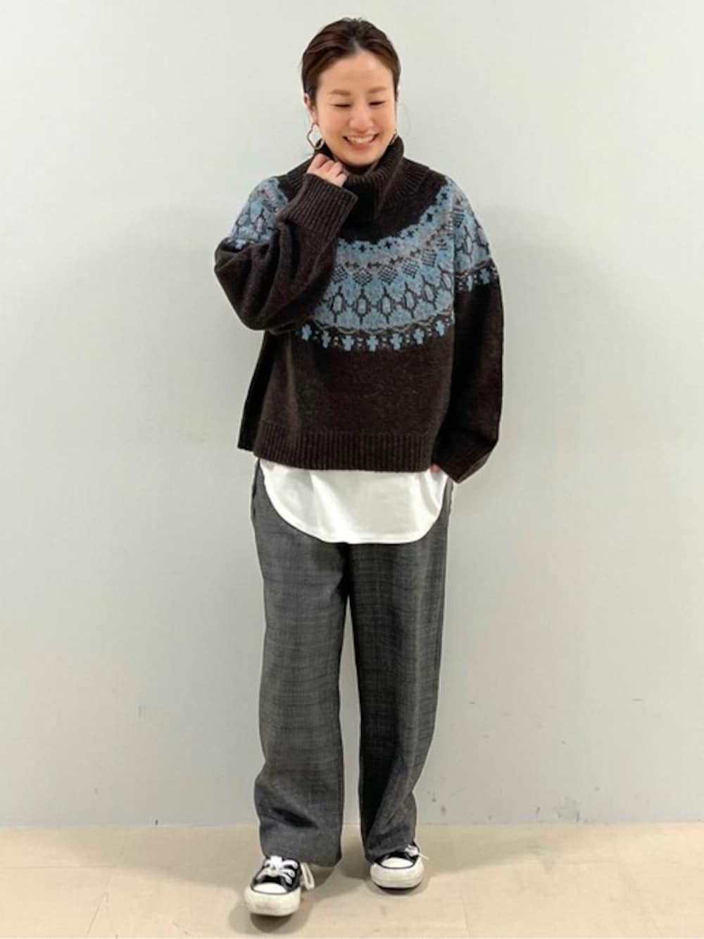 ブラウン系のニット/セーター、ホワイト系のTシャツ/カットソー、グレー系のその他パンツを着用したレディースの秋コーディネートの1枚目の写真